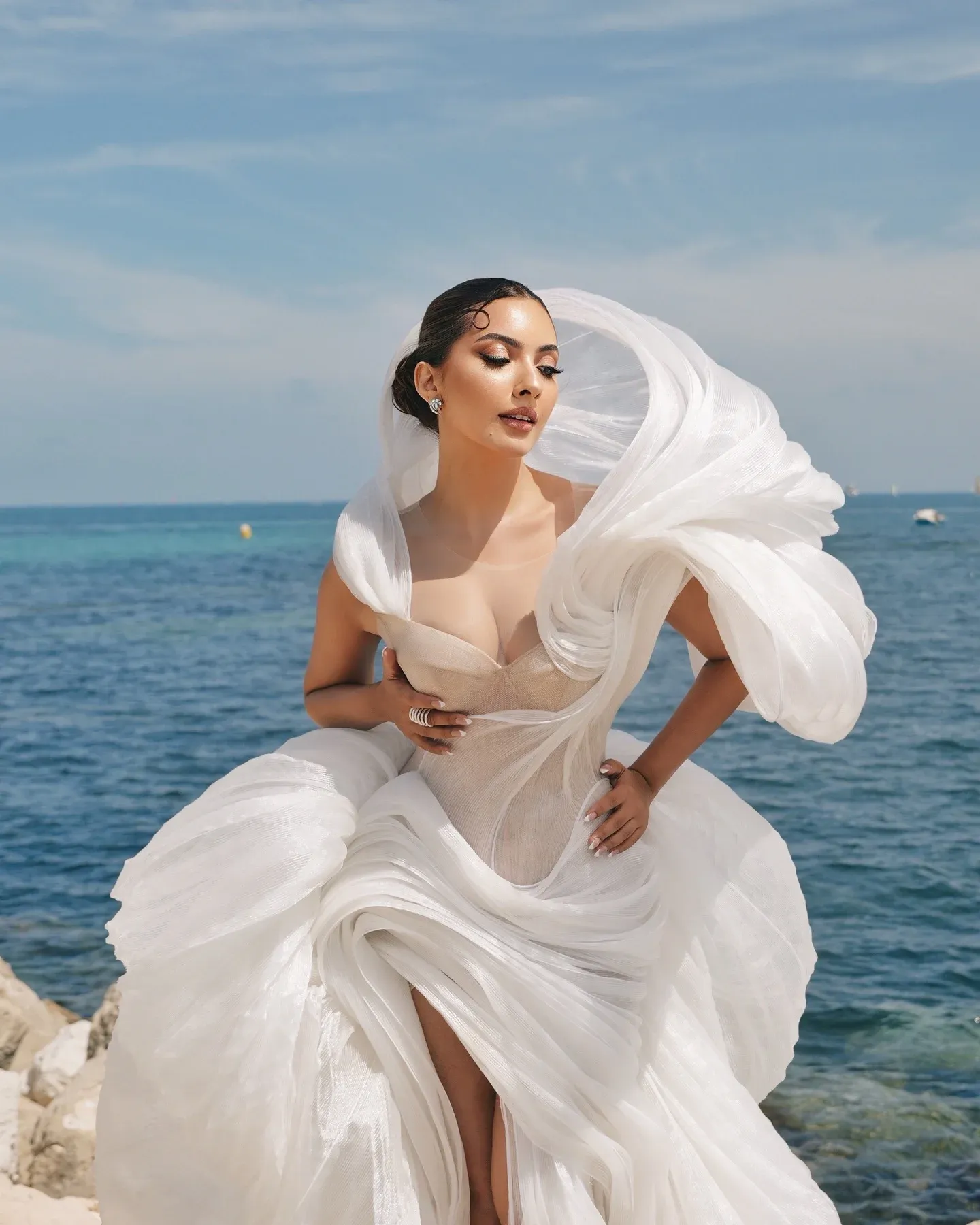 Shooting bord de mer sur la Côte d'Azur — robe blanche volantée sur les rochers, maquillage lumineux