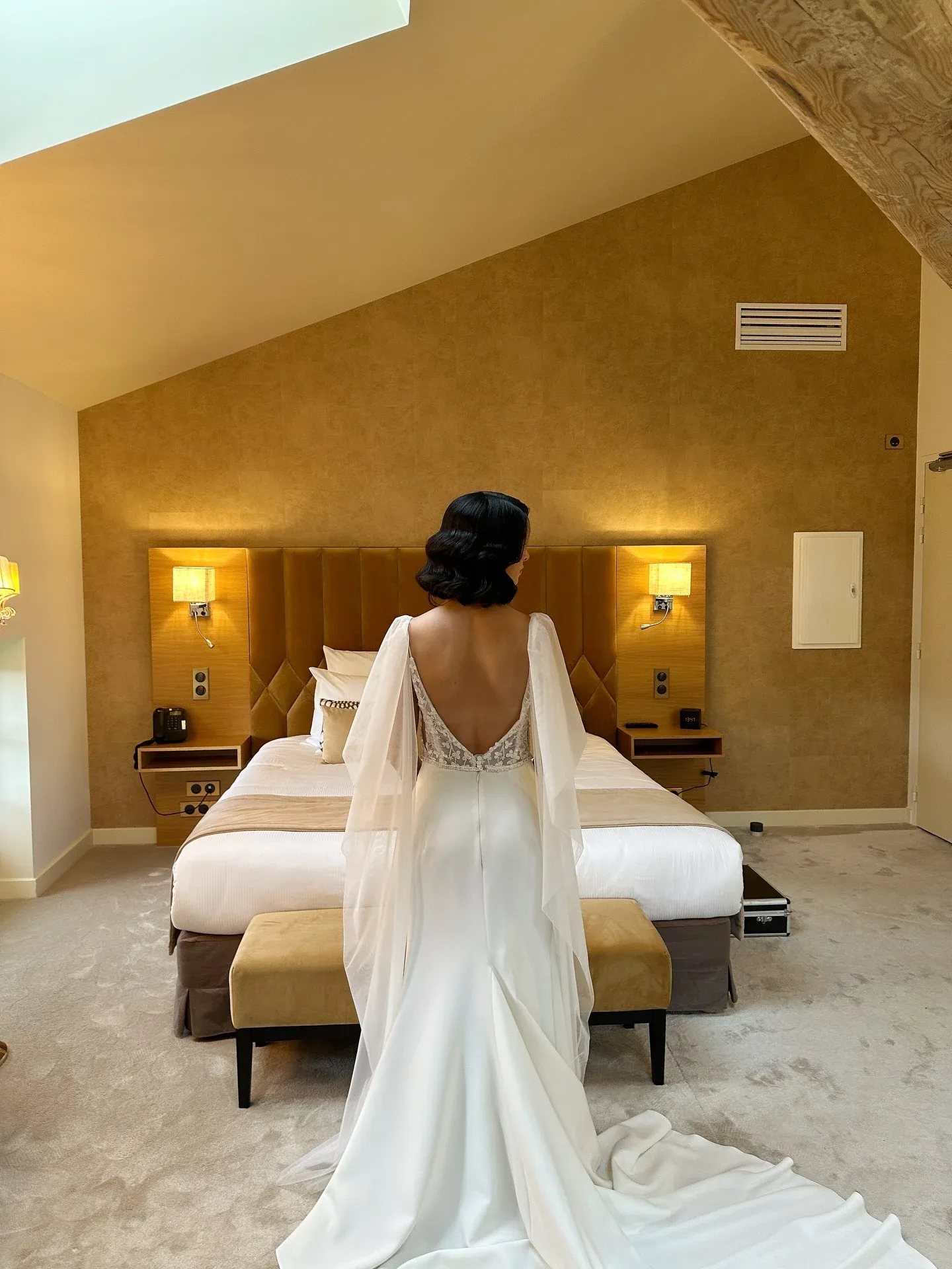Coiffure de mariage rétro wavy — mariée de dos en robe élégante lors des préparatifs à l'hôtel, par Sublimia, coiffeuse mariage à Toulouse