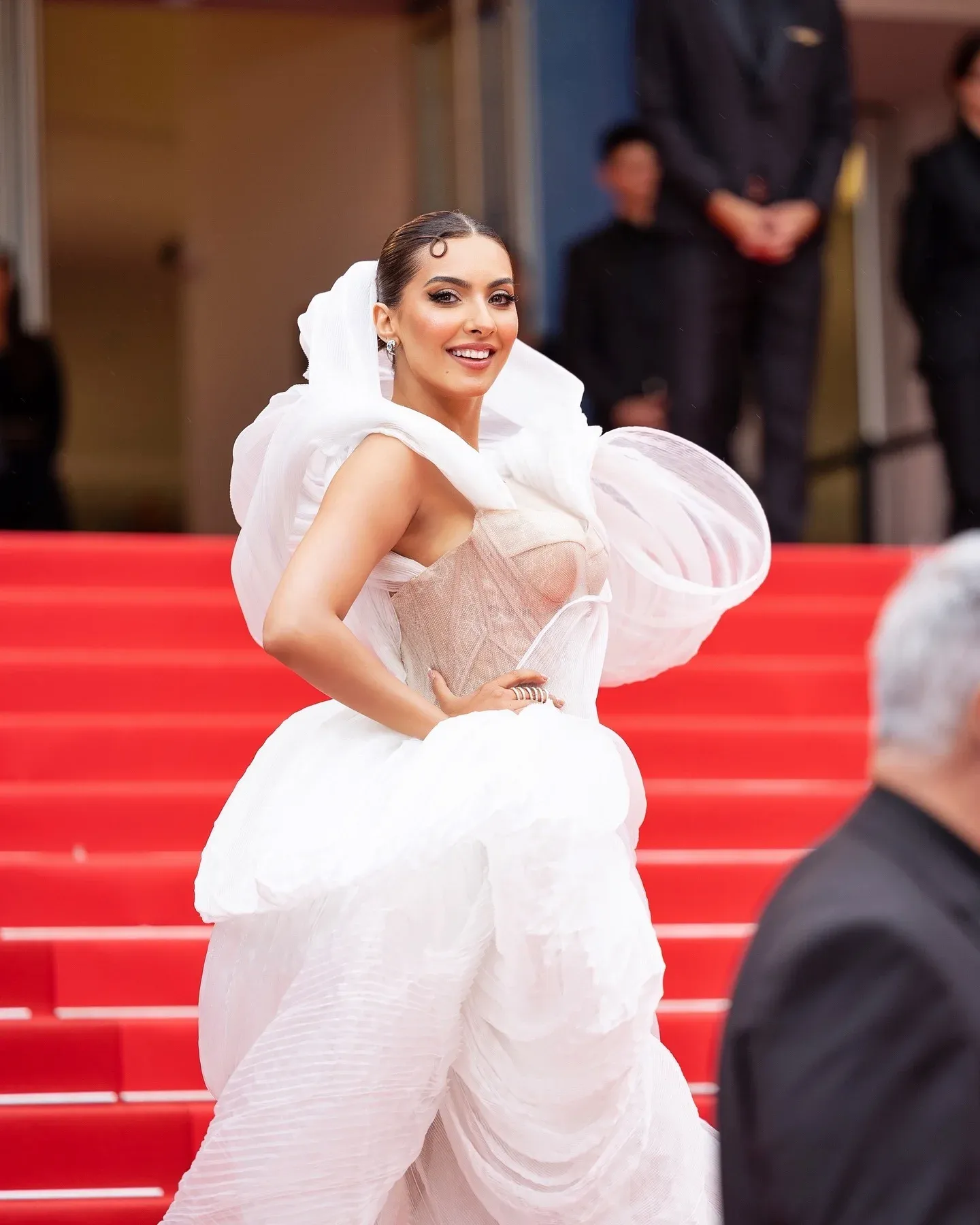 Maquillage professionnel pour la montée des marches du Palais des Festivals à Cannes — robe blanche sculptée et chignon lissé sur le tapis rouge