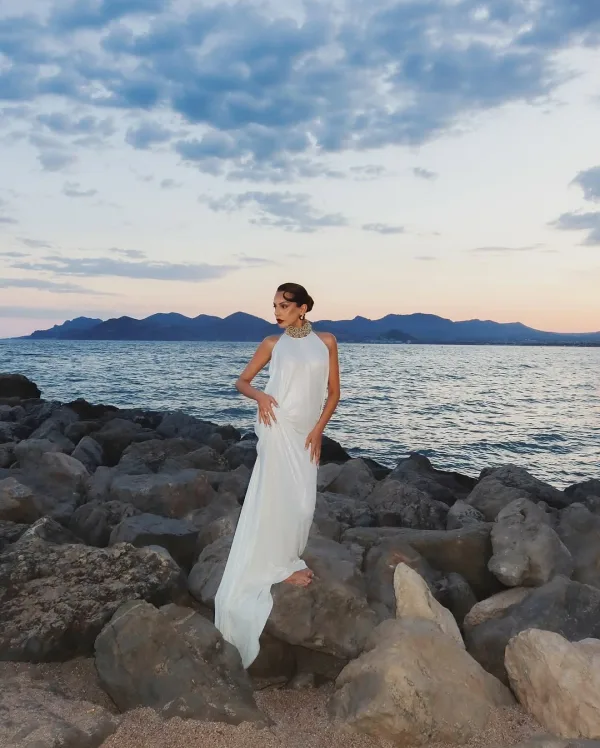Vue panoramique sur rochers de Cannes, robe pailletée longue argentée et maquillage soirée glamour