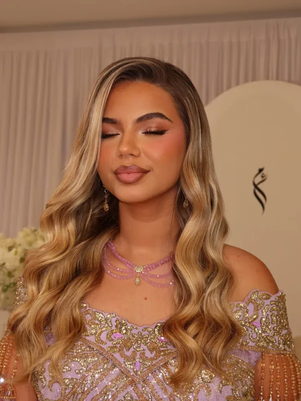 Portrait yeux mi-clos robe lilas brodée or et cheveux blonds ondulés, maquillage naturel Sublimia Toulouse