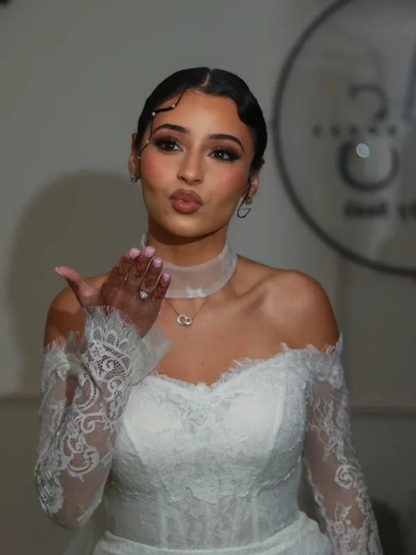Mariée envoyant un bisou, baby hairs perles et robe dentelle épaules nues, maquillage Sublimia Toulouse